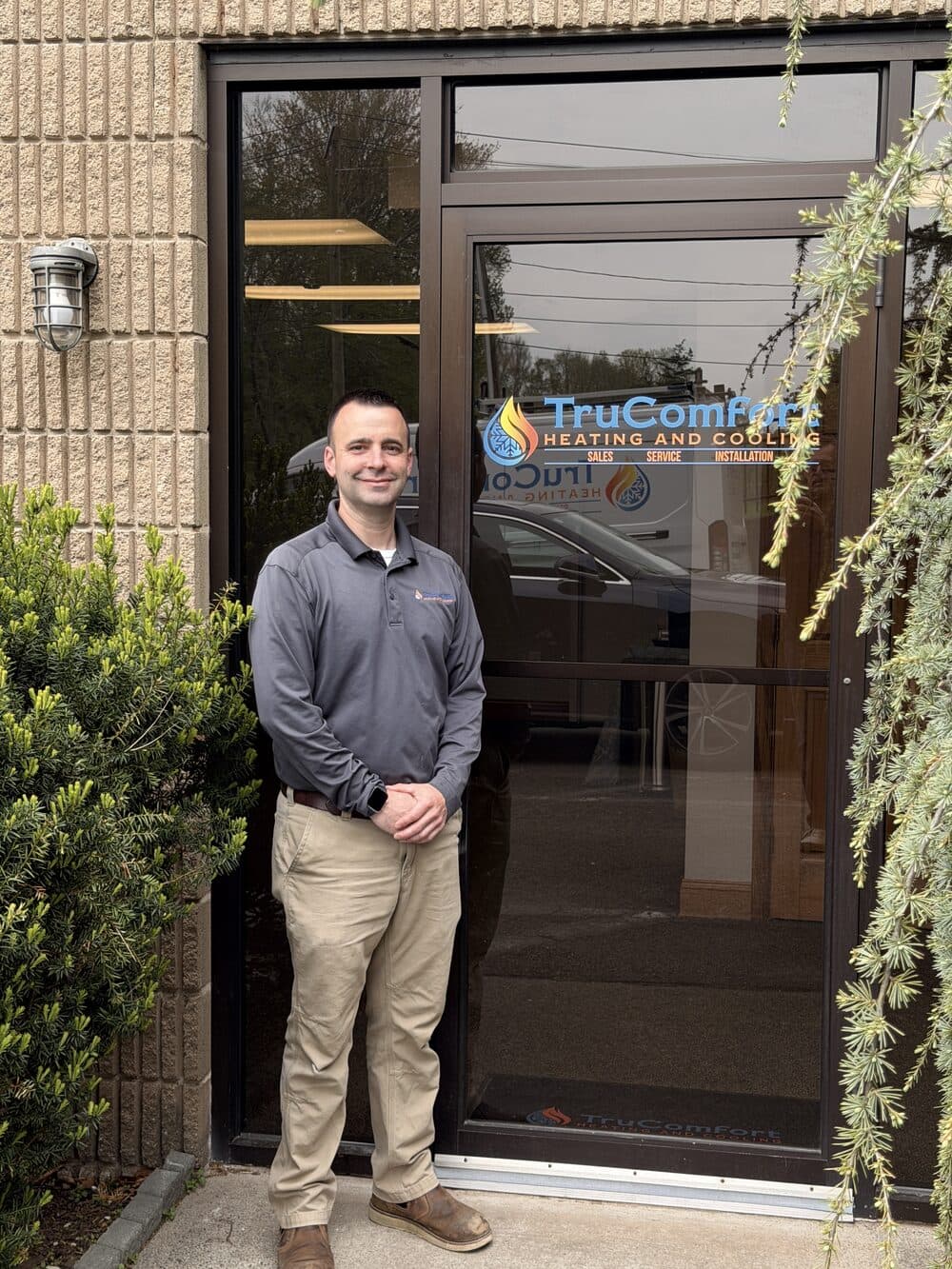 TruComfort owner at the branded front entrance of the Southington office